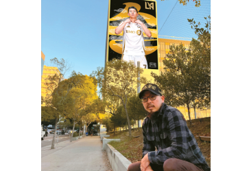 데이브 영 김씨가 자신이 LA 한인타운 내 코스비 빌딩 외벽에 그린 축구 스타 손흥민 대형 벽화 앞에 앉아 있다. [데이브 영 김 제공]