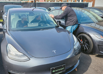 한 중고차 딜러십에서 고객들이 테슬라 차량을 둘러보고 있다. [로이터]