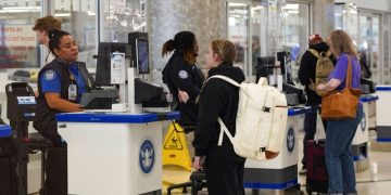 3월 20일, 애틀랜타 하츠필드-잭슨 국제공항에서 승객들이 길게 늘어선 TSA 대기 줄에 기다리는 동안 TSA 요원들이 보안 검사를 수행하고 있다. [로이터]