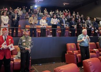 지난 1일 샬롯 극장에서 열린 3·1절 기념식에서 참석자들이 태극기를 들고 기립해있다.