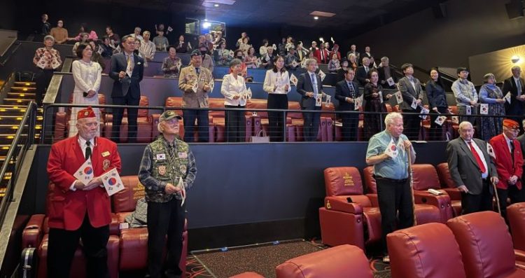 지난 1일 샬롯 극장에서 열린 3·1절 기념식에서 참석자들이 태극기를 들고 기립해있다.