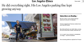 폴 쿡이 주차 위반 티켓을 받은 도로변에 서있다. 도로에는 붉은색 페인트나 주차금지 사인판이 없다.